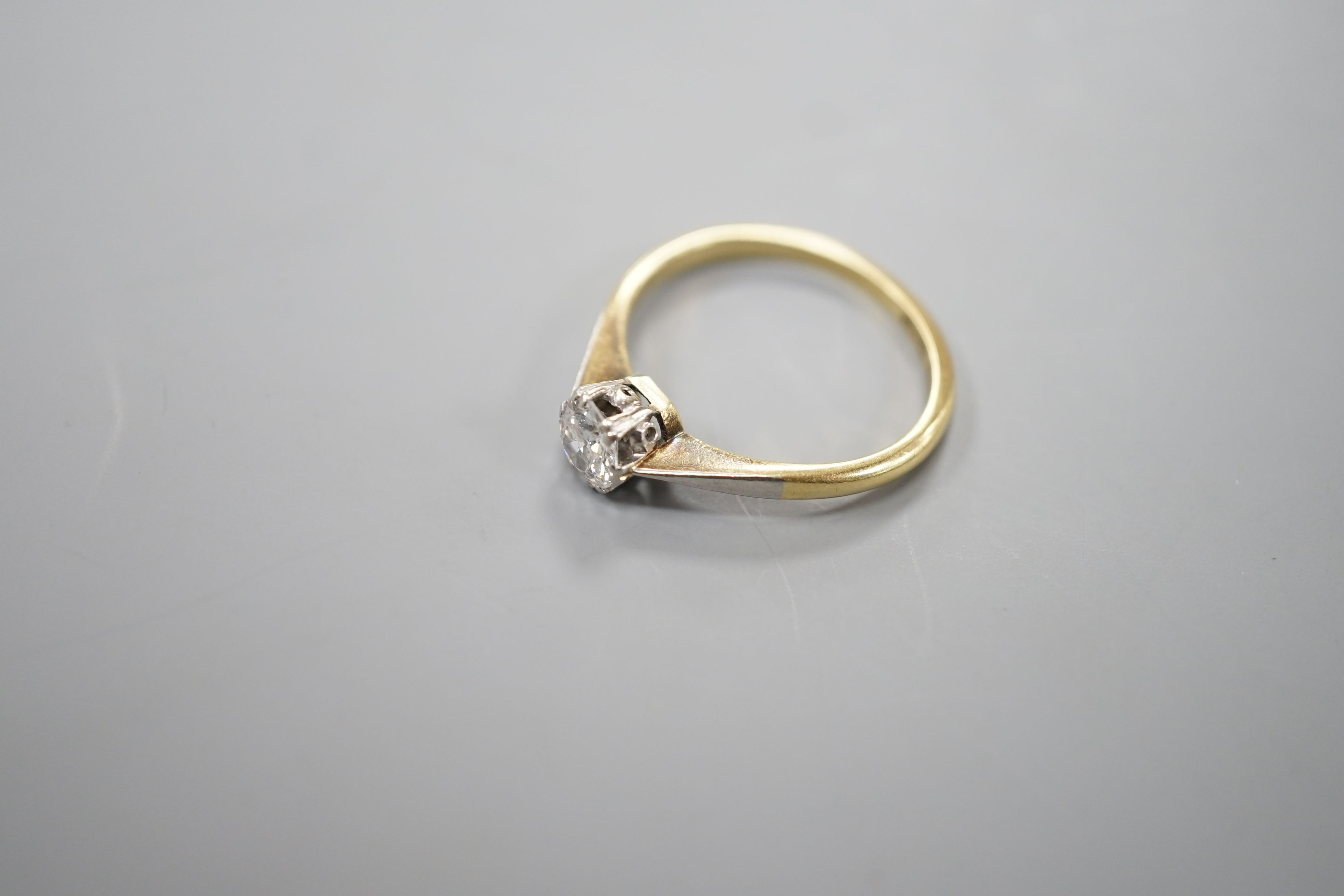 An 18ct gold and platinum solitaire diamond ring, the brilliant cut stone approximately 0.35cts, size M, gross 2.5 grams